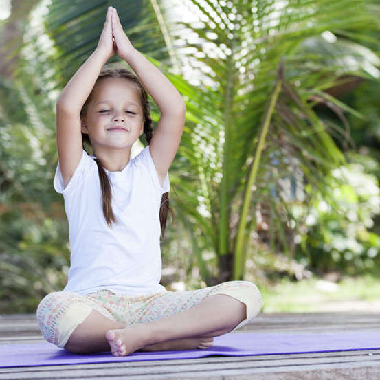 Child doing exercise on platform outdoors. Healthy lifestyle. Yoga girl Child doing exercise on platform outdoors. Healthy ocean lifestyle. Yoga girl